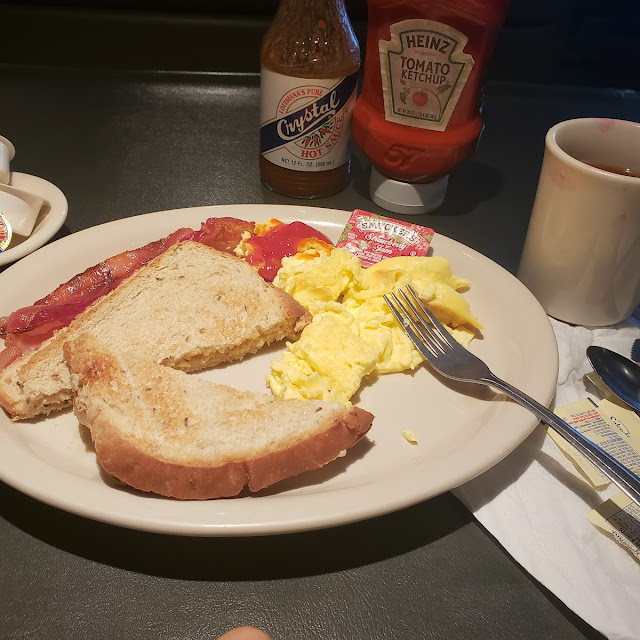 Eggs, toast, bacon, coffee, and condiments